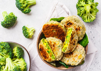 Green broccoli burgers in coconut shell dish on white background, top view.