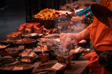 Shaolin Monk life, preparing herbal medicines. Habitat and ritual tools in detail. Religion and philosophy concept. Meditation and Oriental culture in vibrant colors. 