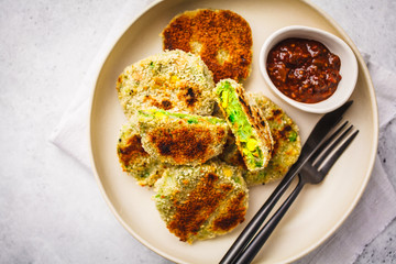 Green Veggie Cutlets in white dish on white background.