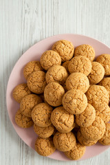 Homemade almond cookies on pink plate on a white wooden background, top view. Flat lay, overhead.