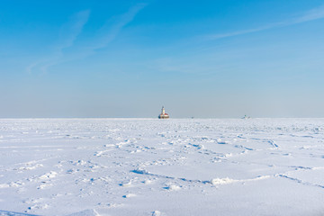 Lake Michigan in Chicago Frozen Over with Snow after a Polar Vortex with a Lighthouse in the distance