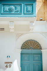 Old maltese blue door and balcony facade in the sun