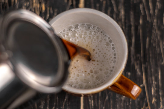 Closeup image of male hands pouring coffee and milk artist and preparation concept, morning coffee.