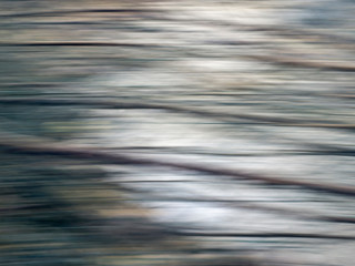 Abstract background from stream, running water and intentional camera movement for blurry effect. Light and shade.