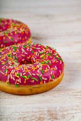 Pink donuts on a wooden background.