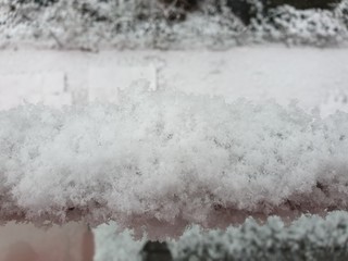 Close-up view of the snow-covered pole of the balcony railing