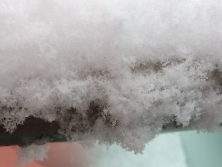 Close-up view of the snow-covered pole of the balcony railing