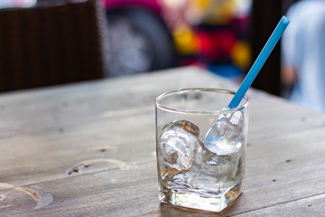 Glass of iced with straw on a wooden table.