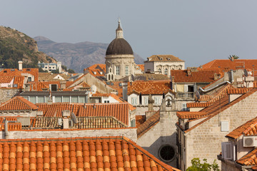 Fototapeta na wymiar DUBROVNIK, CROATIA - AUGUST 22 2017: View from the top of town walls of Dubrovnik roofs, with Cathedral dome