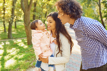 Fototapeta premium Happy family standing playing in the park. 