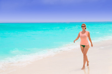 Fototapeta na wymiar Gorgeous woman on the sandy beach with turquoise ocean