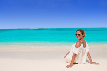 Beautiful woman in sunglasses tans at the dream beach