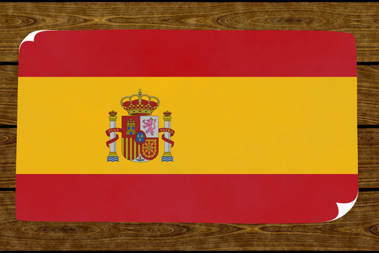 Illustration of a Spanish flag on the paper pasted on the woody wall