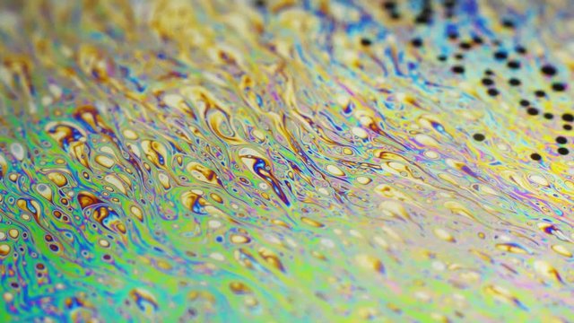 Amazing colorful background formed of motion multicolored surface of soap bubble