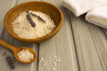 Sea bath salt,dried lavender and white towels on the grey wooden background