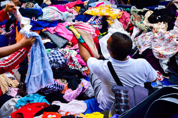 Vendor selling cheap clothes on the street of traditional old open market