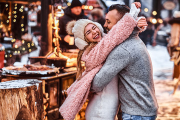 A cheerful attractive couple in love, enjoying spending time together while embracing at the winter...