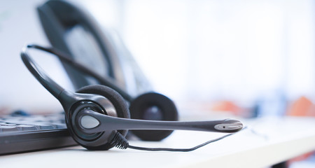 close up on headset call center with telephone at office monitoring operation room concept