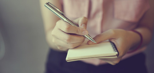 close up businesswoman hand writing content or somethings on notebook 