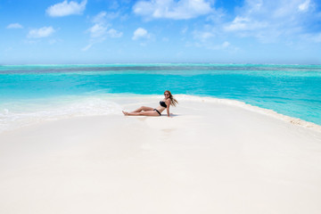 Fototapeta na wymiar Blonde Girl in black bikini on dream beach at the turquoise ocean
