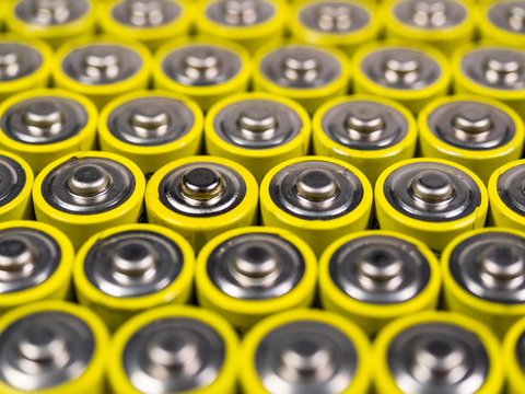 Huge number of AA batteries of yellow color. Batteries for use in the different equipment