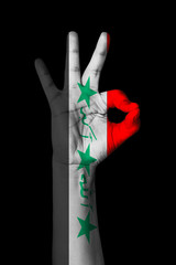 Hand making Ok sign, Iraq flag painted as symbol of best quality, positivity and success - isolated on black background
