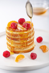 Fresh homemade pancakes with raspberry fruits and honey