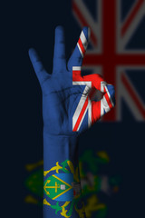 Hand making Ok sign, pitcairn islands flag painted as symbol of best quality, positivity and success - isolated on flag background