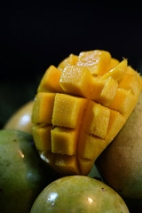 Ripe peeled and unpeeled mango on papaya leaf and space for write wording, popular sweet tropical fruit, important export product, high calories and sugar level caused diabetes and other illness