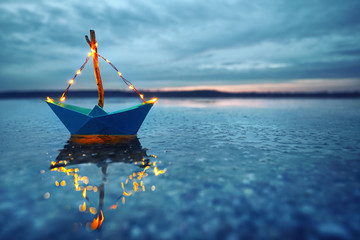 romantischer Abend - leuchtendes Boot am Strand