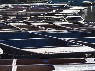 Cambridge, England. Group of empty wooden boats during the winter time used for tours around the Cambridge University colleges along the river Cam