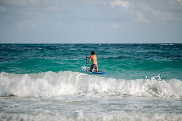 Man sails surfing on the waves in the Caribbean, in Cancun, Mexico