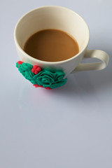 Coffee mug decorated with polymer clay flowers. Crafts from polymer clay. Mug decorated with stucco made of polymer clay