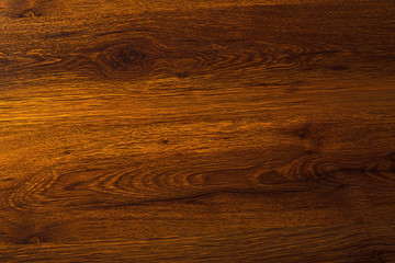 Polished wood texture. The background of polished wood texture with a dark amber color