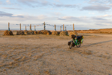 Tourist bicycle and Mongolian Ovoo, Ceremonial Rock Pile on Mountain Top, Mongolia.
