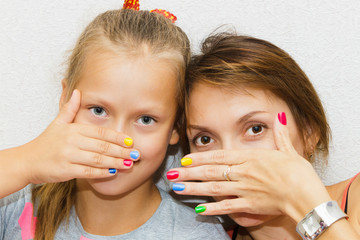 Hands of mother and daughter manicure.