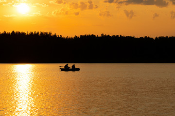 Fishermen catch fish on the lake at sunset.