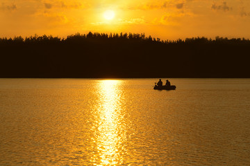 Obraz na płótnie Canvas Fishermen catch fish on the lake at sunset.