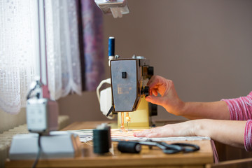 woman hands using sewing machine on a sewing manufacture, sewing process