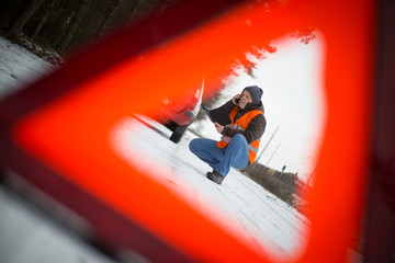 man calling the roadside service / assistance after his car has broken down, car problem concept during winter time