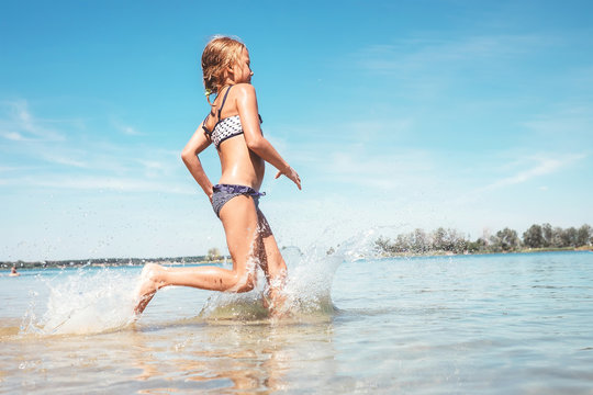 Little girl run in river water. Summer days fun time