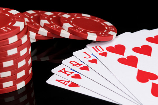red poker chips and playing cards concept on a black background