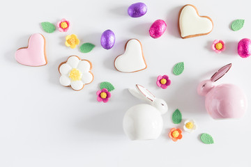 Easter eggs, cookies, sweets, porcelain rabbit, easter decorations on white background. Minimum...