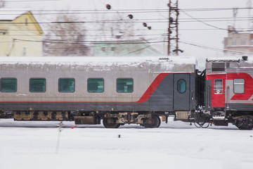 Fototapeta premium passenger train travels fast along a snowy railroad