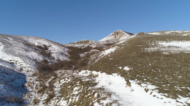 Alps - aerial view. Mountains under the snow in winter. Panorama of snow mountain range landscape with blue sky
