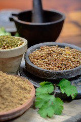 Clay bowls wirh dried coriander seeds and coriander powder close up, spices collection