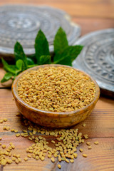 Bowl with fenugreek seeds close up, used for cooking and traditinal medicine, spices collection