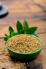 Bowl with fenugreek seeds close up, used for cooking and traditinal medicine, spices collection