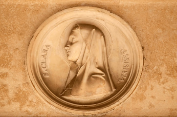 Saint Clare of Assisi, bass relief in portico of church dei Santi XII Apostoli in Rome, Italy 