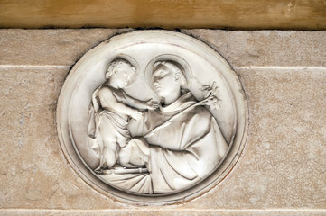 Saint Anthony of Padua bass relief in portico of church dei Santi XII Apostoli in Rome, Italy